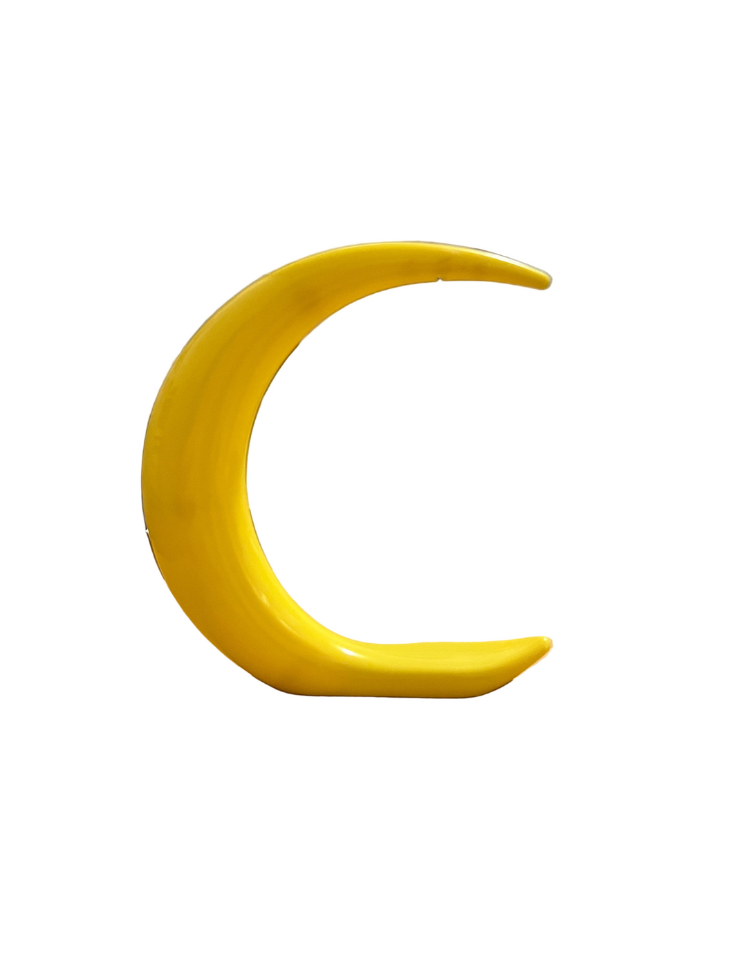 Yellow plastic moon that stands up on a shelf.
