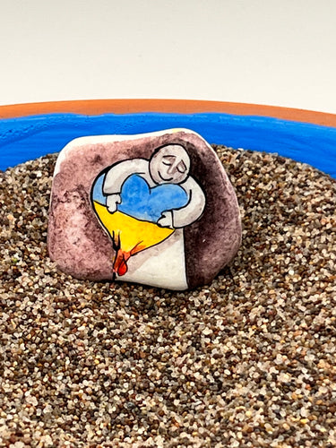 Person hugging Ukrainian heart